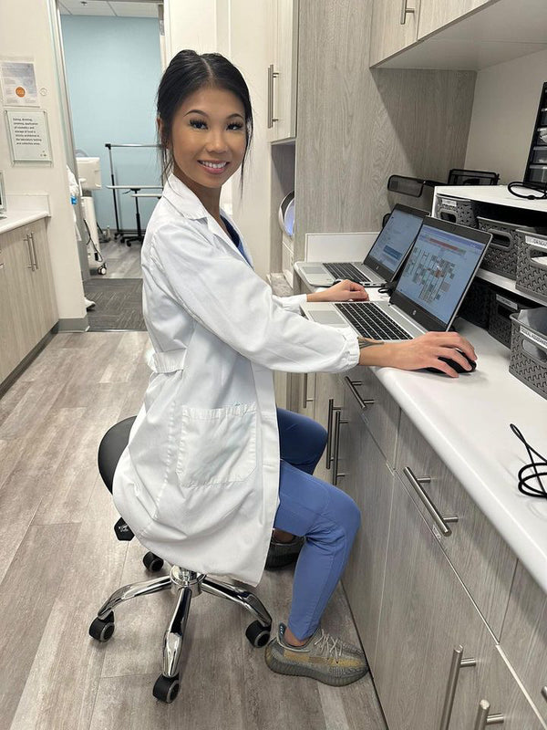 Dentist working at a computer from a saddle stool