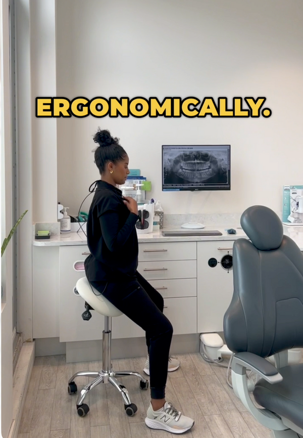 Hygienist seated on a saddle stool in an operatory