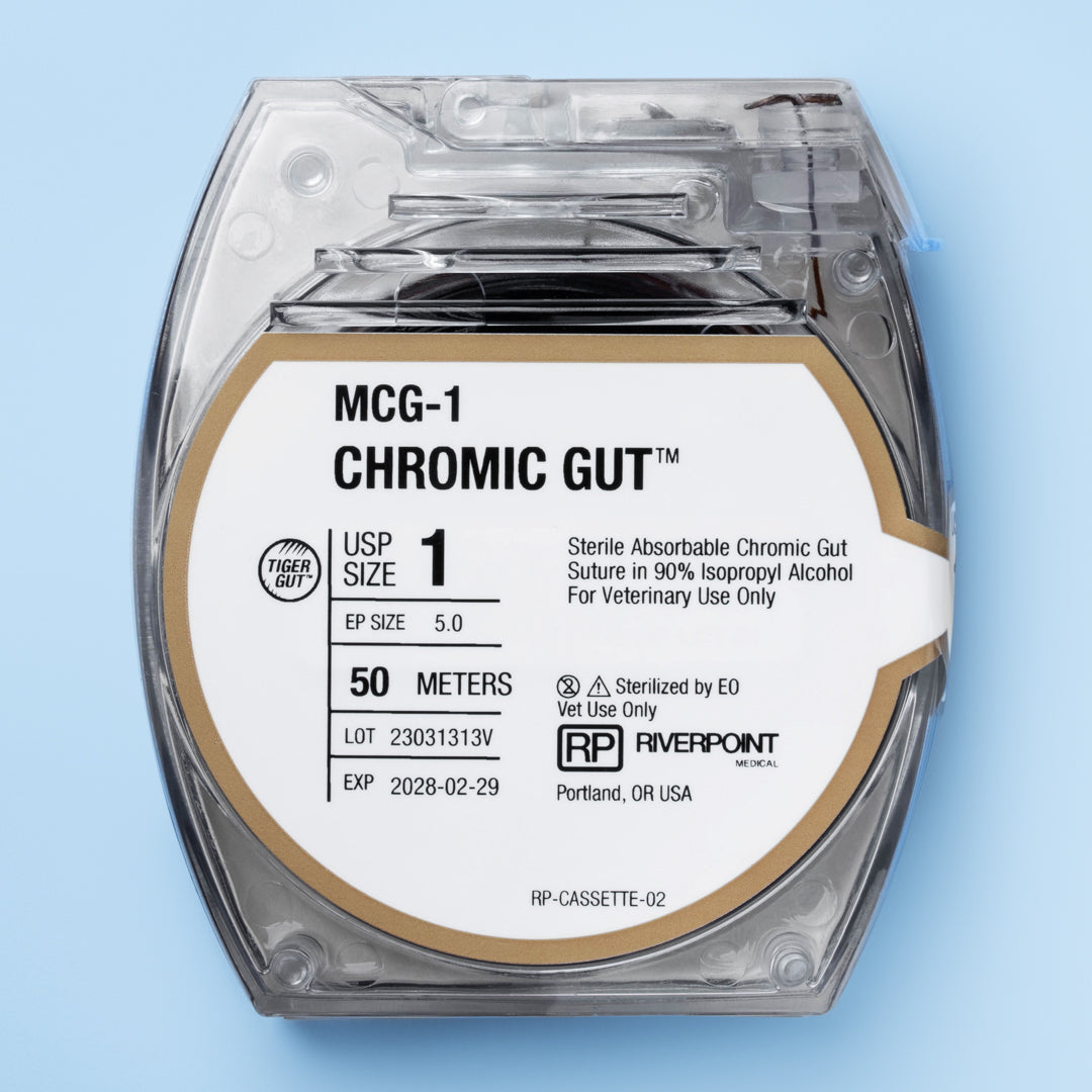 Close-up of the RIVERPOINT MCG-1 Chromic Gut suture cassette, showing a 50-meter violet suture coil, size 1 (Ep 5.0), designed for veterinary surgical use. The label details gamma irradiation sterilization, wound support for 2 weeks, and ethylene oxide (EO) sterilization method. Manufactured by RIVERPOINT in Portland, OR, USA, highlighting its suitability for various surgical applications with a focus on safety, performance, and ease of use.
