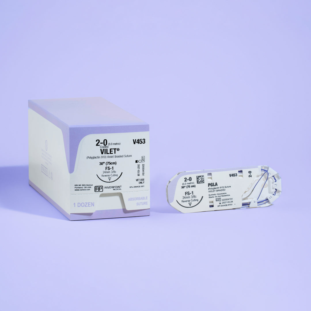 Photograph showing the 2-0 VILET® Violet 30" FS-1 Needle (V453) alongside its open sterile packaging, illustrating the product details and its preparation for veterinary surgeries, manufactured by Riverpoint Medical.