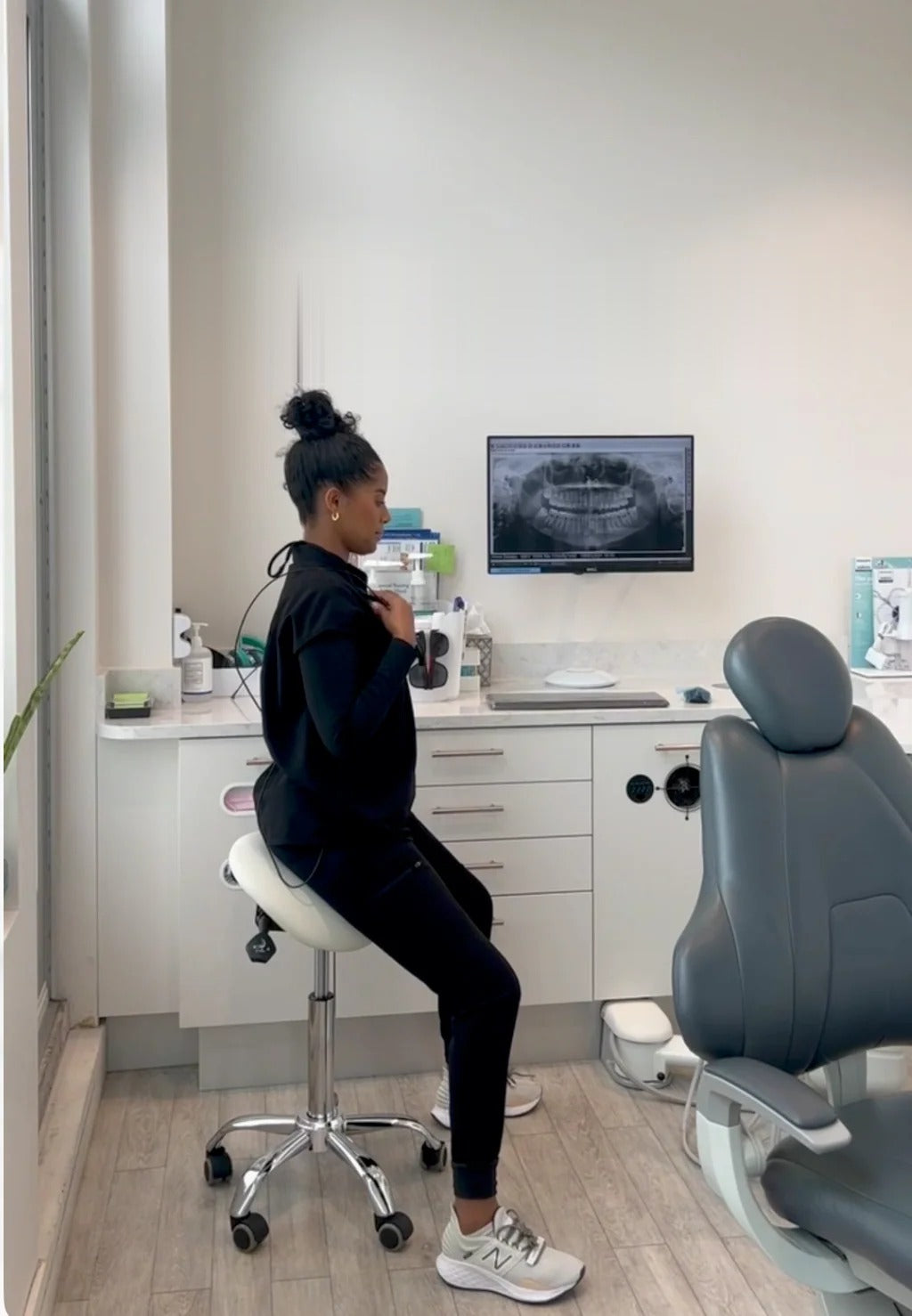 Hannah, a dental hygienist, seated upright on a ProNorth saddle stool in her operatory